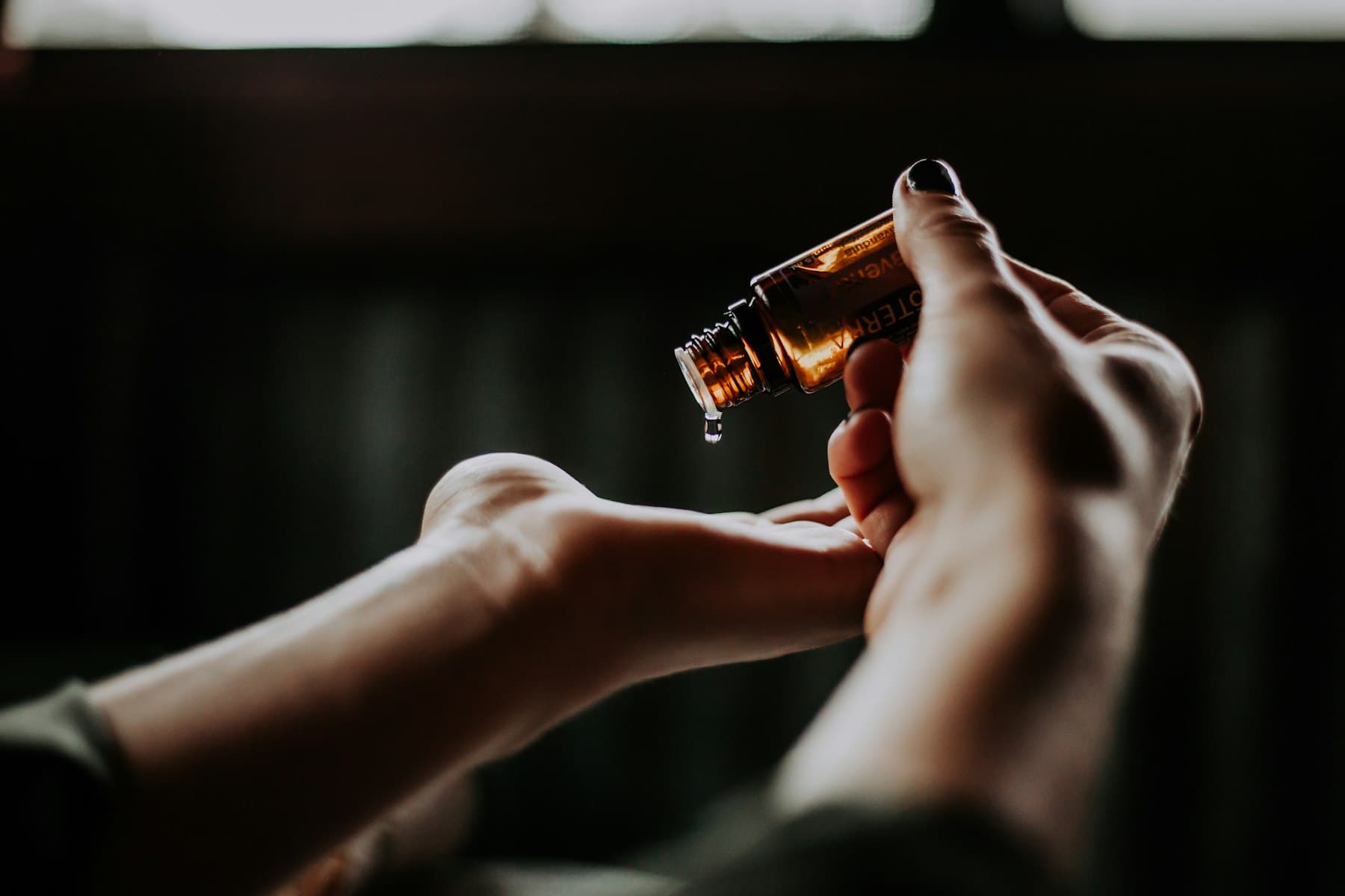 Gloved hands preparing a wellness serum in warm natural light